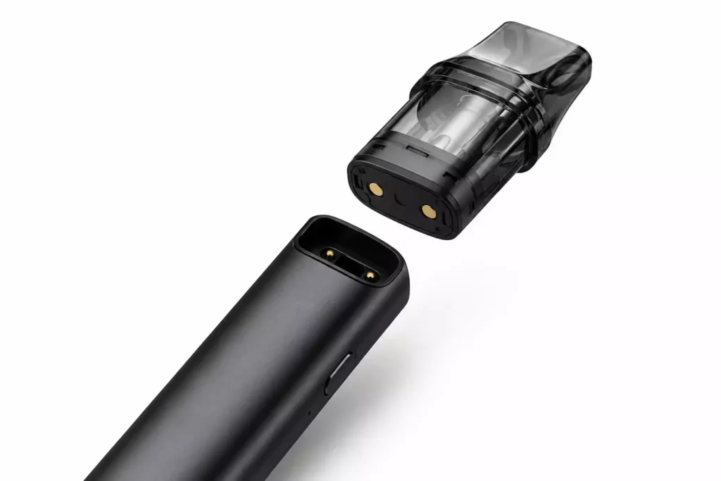 A high-end macro product shot showing a clear plastic pod cartridge detached from an authentic matte black electronic battery housing unit.